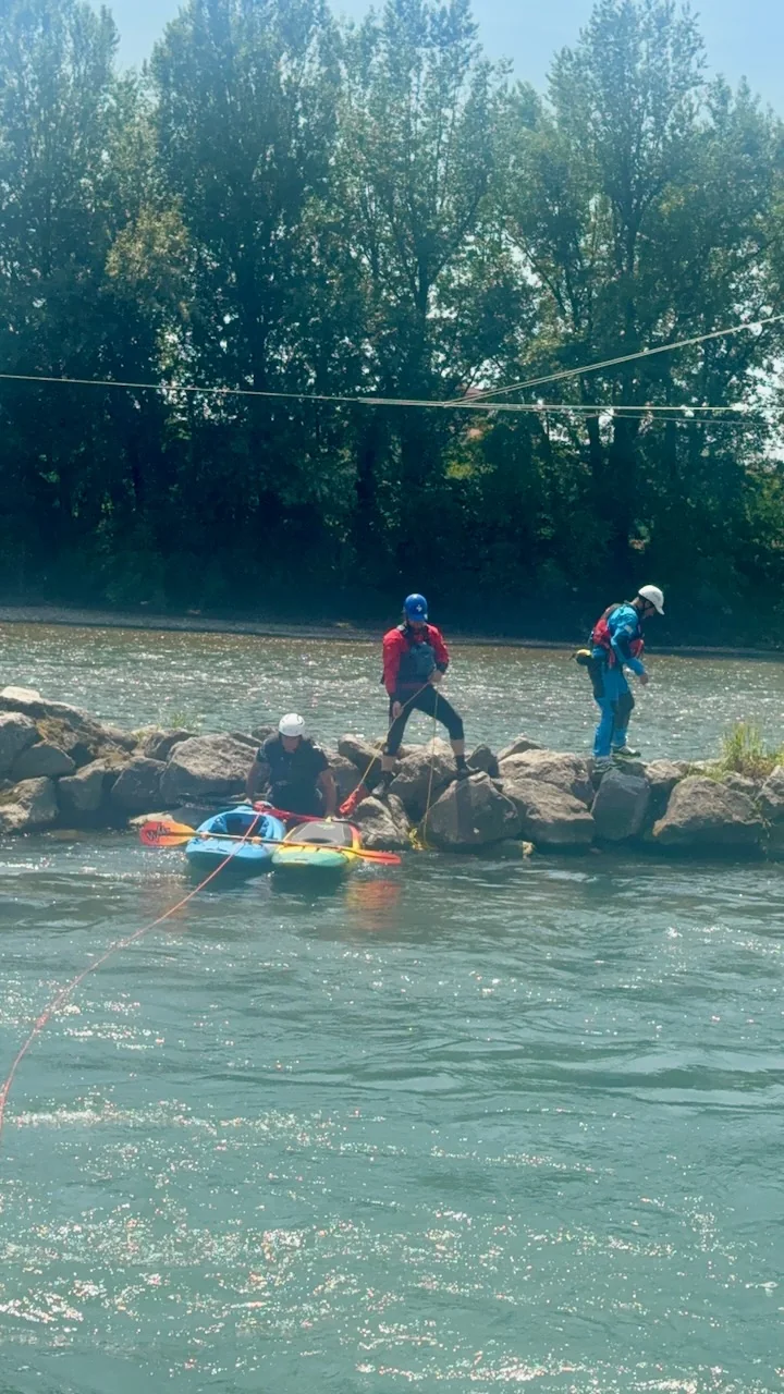 Partecipante al corso WRT-PRO impegnata nel recupero di un kayak bloccato su una roccia