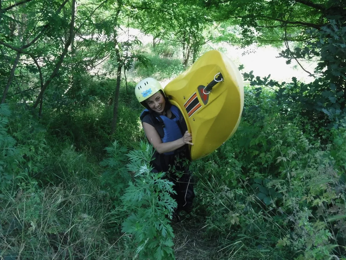 Partecipante trasporta il kayak durante una lezione introduttiva nel Parco del Ticino
