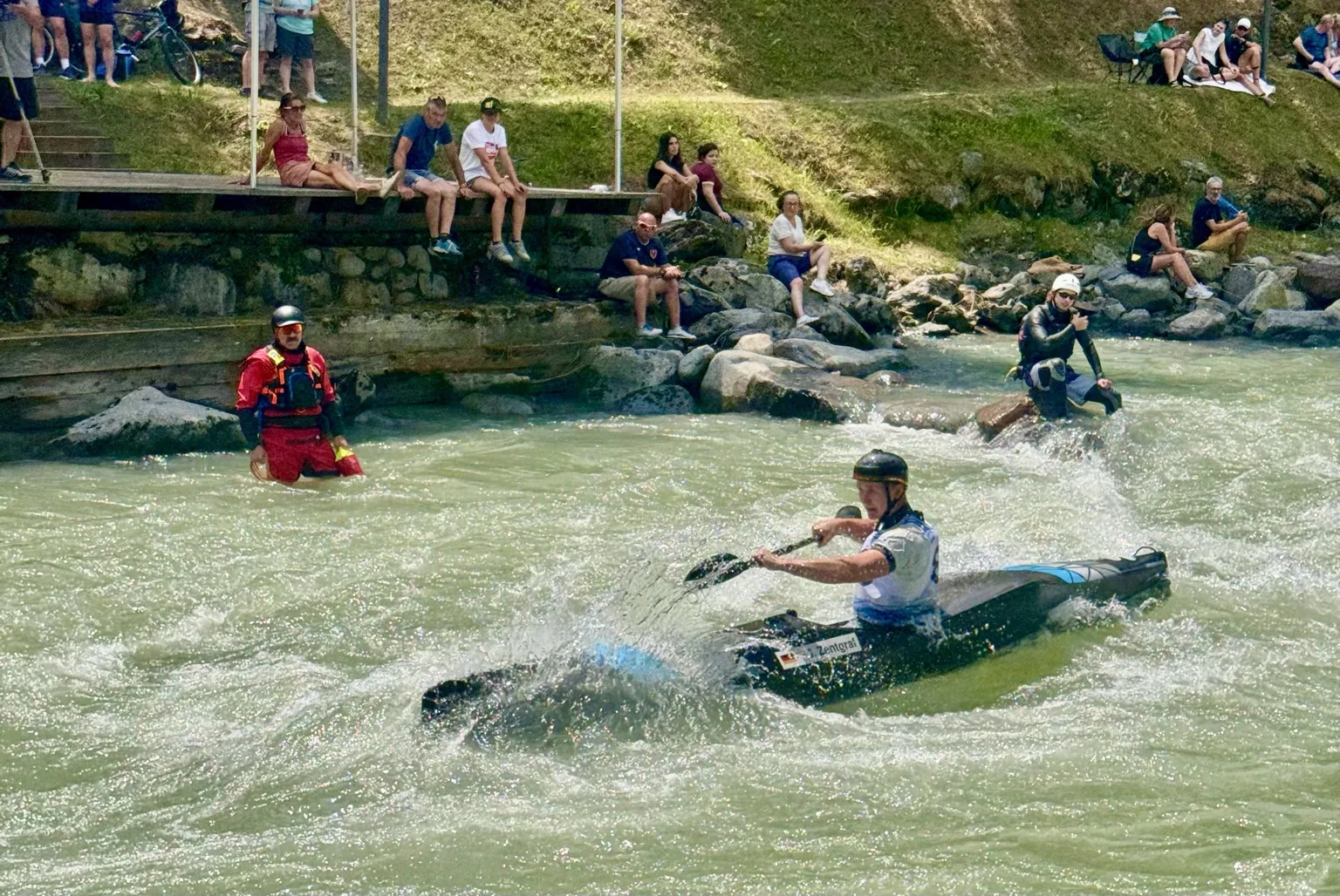 Canoista in gara sul fiume Noce con soccorritori in presidio operativo durante la World Cup Val di Sole 2026