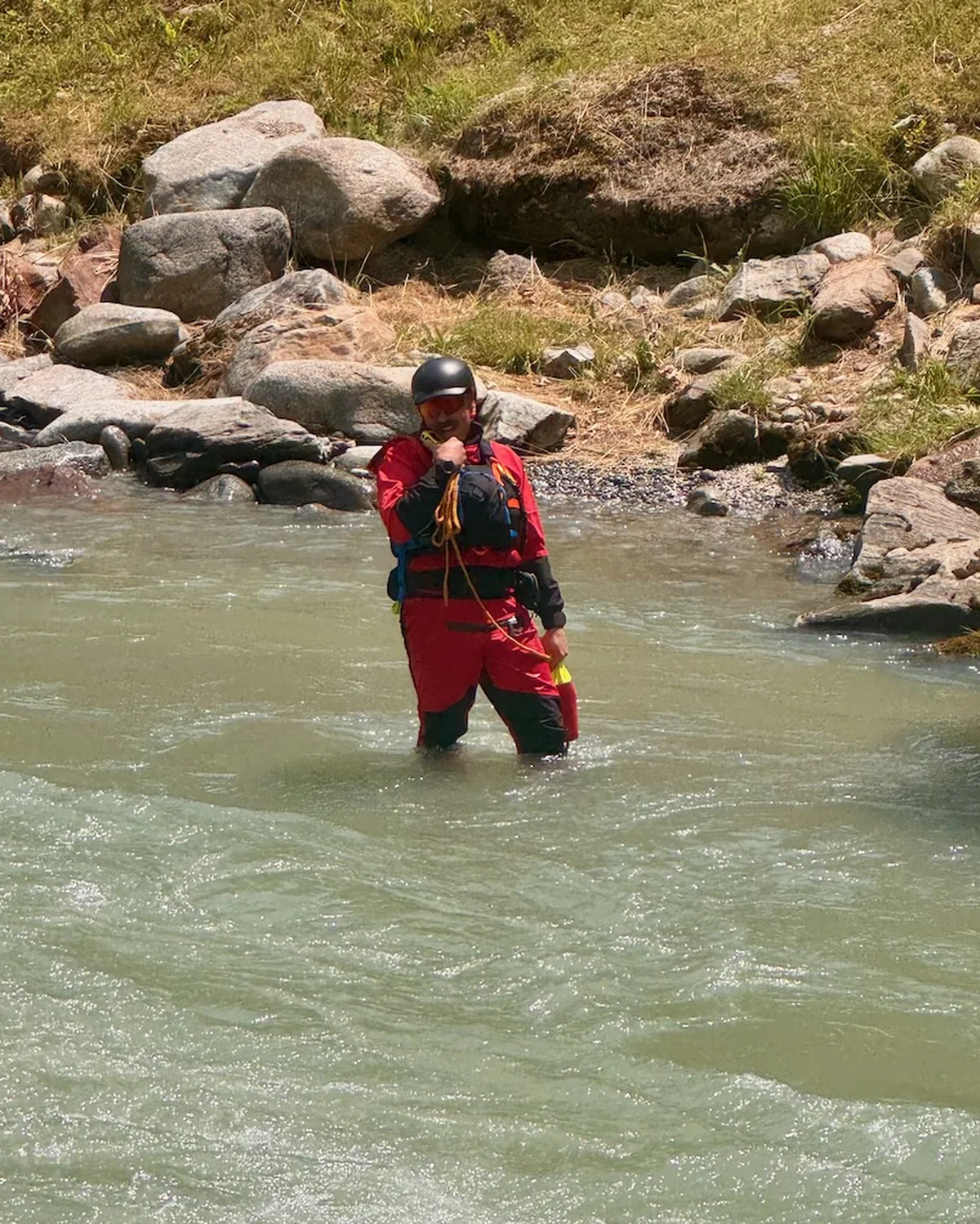 Soccorritore in piedi nel fiume Noce durante il presidio del campo gara in Val di Sole 2026